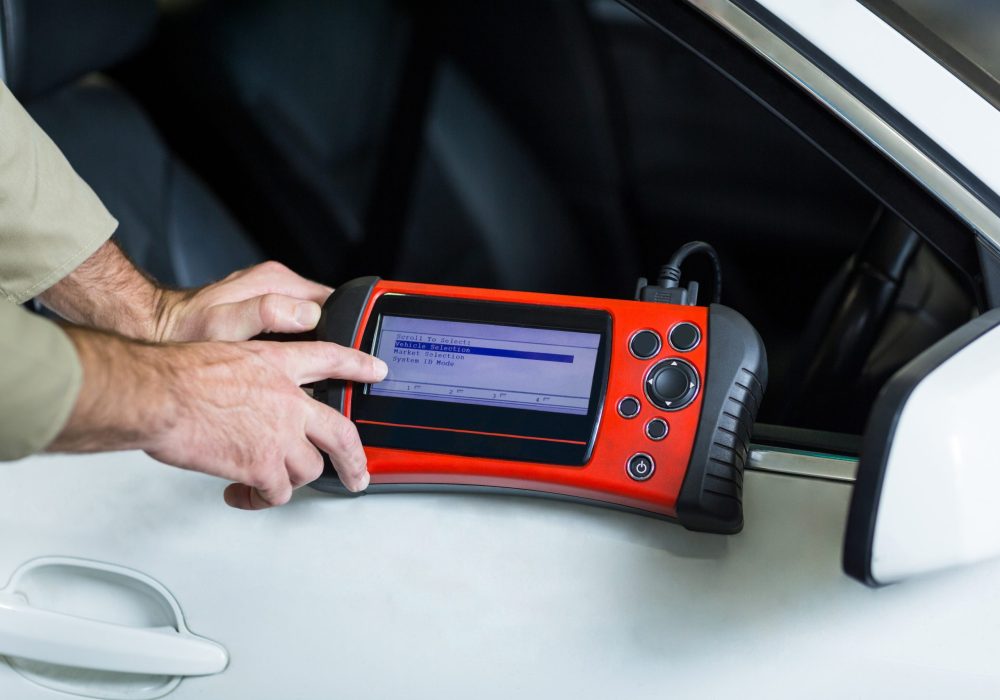 Hands of mechanic using a diagnostic tool in repair garage