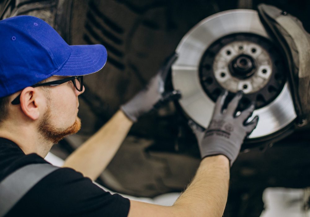 Mechanic changing brake discs in car service